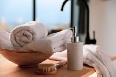 Temiz havlular, sabun makinesi ve banyo fırçası.