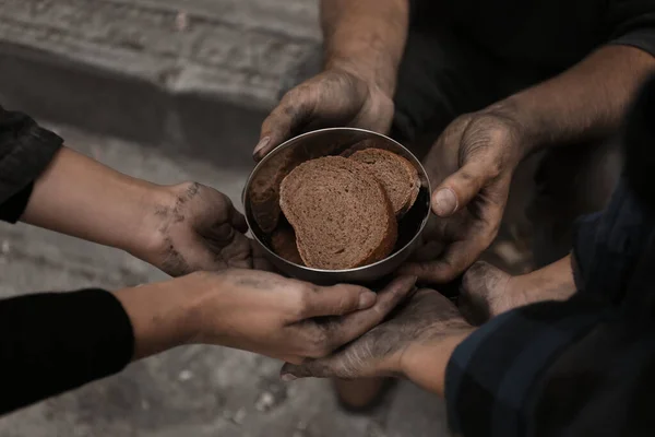 Poor homeless people with pieces of bread outdoors, closeup — Stock Photo, Image