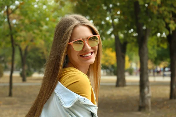 Jonge vrouw met een stijlvolle zonnebril in het park — Stockfoto