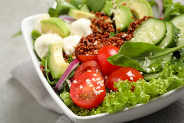 Deliciosa salada de abacate com quinoa em mesa cinza claro, close-up — Fotografia de Stock