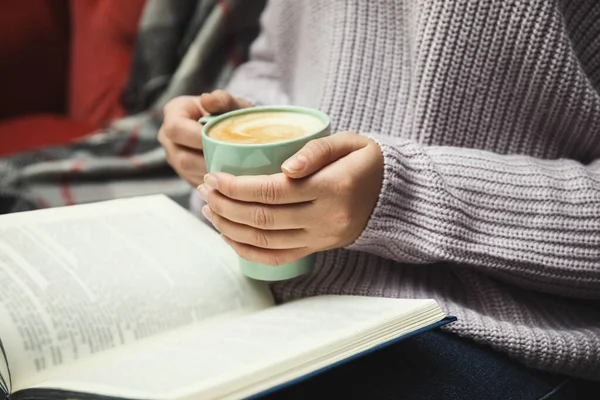 Mujer con taza de libro de lectura de café en casa, primer plano —  Fotos de Stock