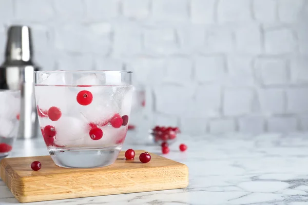 Copo de coquetel com vodka, gelo e cranberry na mesa de mármore branco. Espaço para texto — Fotografia de Stock