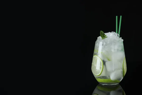 Bicchiere di cocktail con vodka, ghiaccio e lime su fondo nero. Spazio per testo — Foto Stock