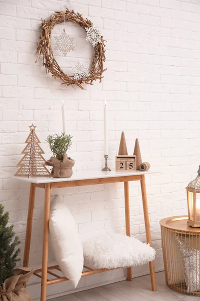 Konzolos asztal karácsonyi dekorációval közel téglafal. Ötlet az ünnepi belső tér kialakításához — Stock Fotó