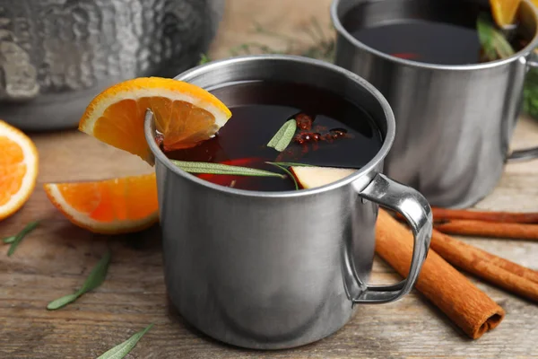 Vinho quente saboroso com especiarias na mesa de madeira — Fotografia de Stock