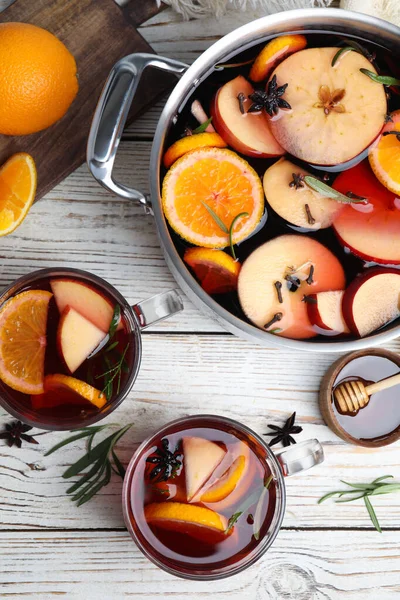 Tasty mulled wine with spices on white wooden table, flat lay — Stock Photo, Image
