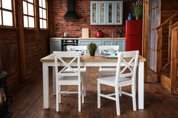 Stylový interiér kuchyně s jídelním stolem a židlemi — Stock fotografie