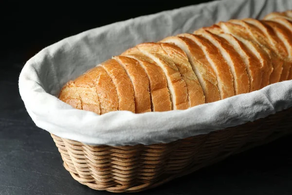 Slices of bread in basket on black table, closeup — Stockfoto