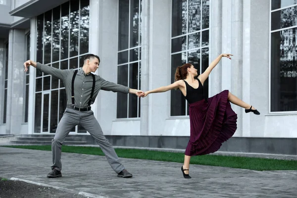 Beau jeune couple pratiquant des mouvements de danse sur la rue de la ville — Photo