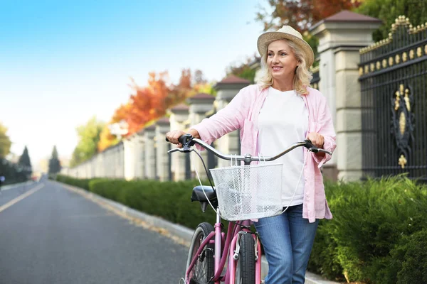 Mujer madura con bicicleta al aire libre. Estilo de vida activo — Foto de Stock