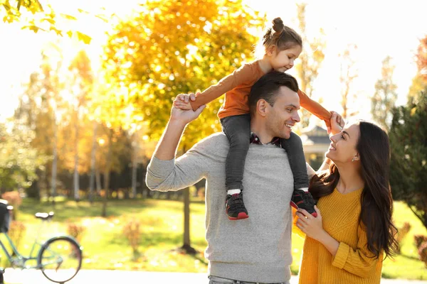 Lycklig familj med liten dotter i parken. Höstvandring — Stockfoto