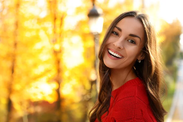 Hermosa mujer vistiendo suéter rojo en el soleado parque. Caminata de otoño —  Fotos de Stock