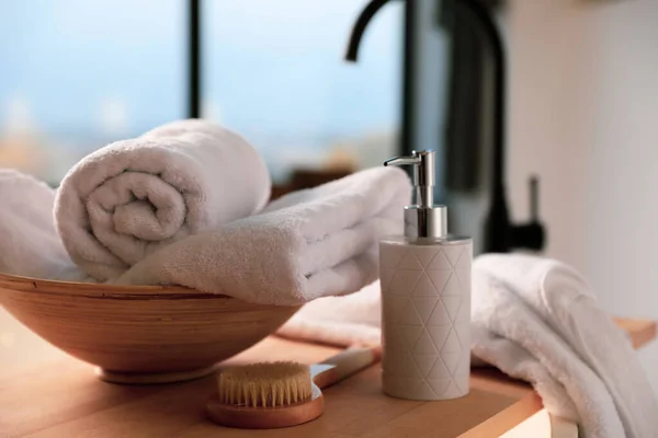 Toallas limpias, dispensador de jabón y cepillo de ducha en el baño —  Fotos de Stock