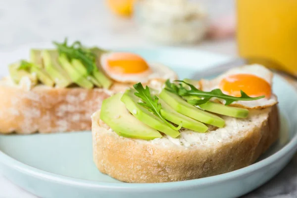 Tallrik med läckra avokado smörgåsar på bordet, närbild — Stockfoto