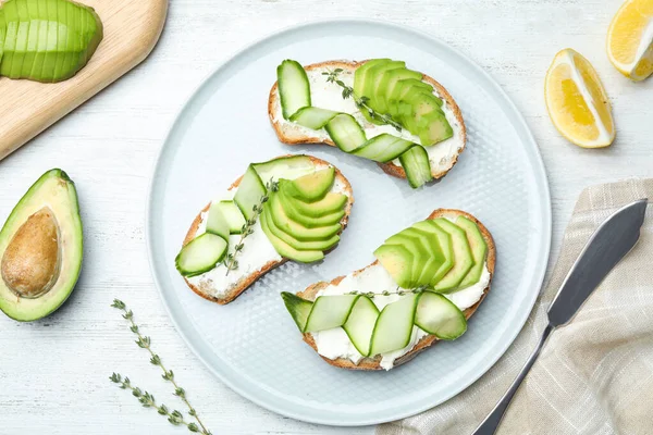 Platte lay compositie met lekkere avocado sandwiches op witte houten tafel — Stockfoto
