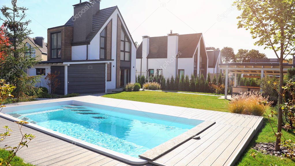 New modern house with backyard swimming pool on sunny day