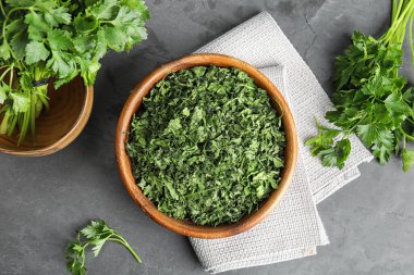 Gri taş masanın üzerinde taze ve kurutulmuş maydanozla düz bir kompozisyon vardı.