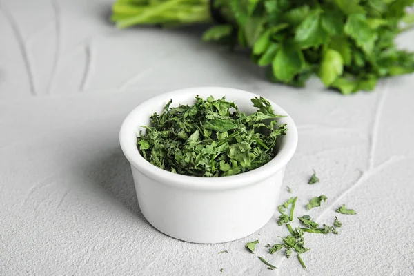 Bowl of dried parsley on grey stone table