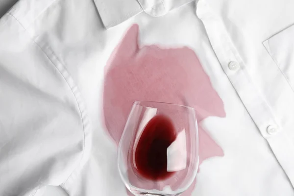 Glas umgeworfen und exquisiter Rotwein auf weißem Hemd verschüttet, Draufsicht — Stockfoto