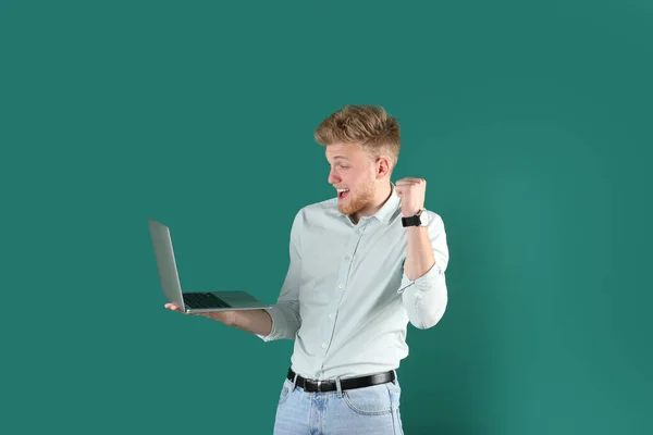 Emotionele man met laptop op groene achtergrond — Stockfoto