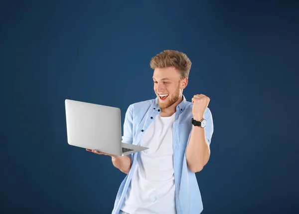 Emotionele man met laptop op blauwe achtergrond — Stockfoto