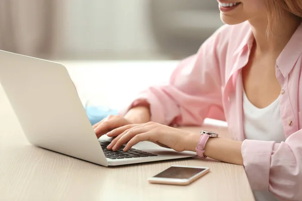 Giovane donna che utilizza il computer portatile a tavola in casa, primo piano — Foto Stock