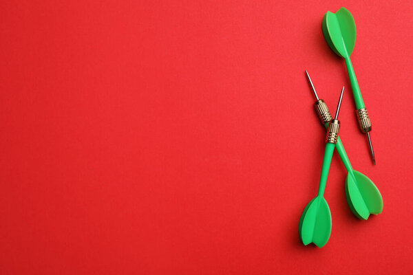 Зеленый дротик стрелки на красном фоне, плоский лежал с пространством для текста
