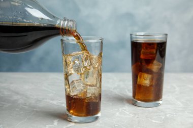 Mavi arka plan karşı masada cam içine ferahlatıcı soda içecek dökme