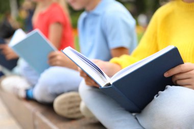 Dışarıda kitap okuyan küçük çocuklar, yakın çekim.