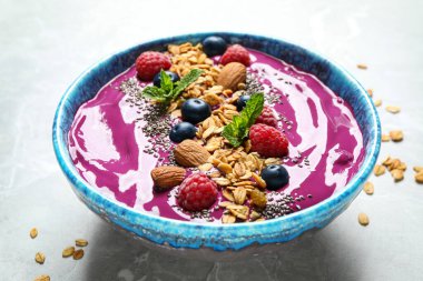 Granola ile nefis acai smoothie ve tatlı kasesinde hafif mermer masa üzerinde böğürtlen