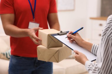 Paketleri eve teslim eden kadın, yakın çekim. Kurye servisi