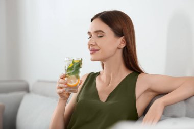 Evde limonata lı genç bir kadın. Ferahlatıcı içecek