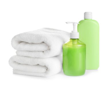 Beyaz arka planda katlanmış yumuşak havlular ve tuvalet malzemeleri