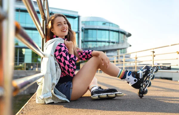 Hermosa mujer joven con patines de ruedas sentado al aire libre —  Fotos de Stock