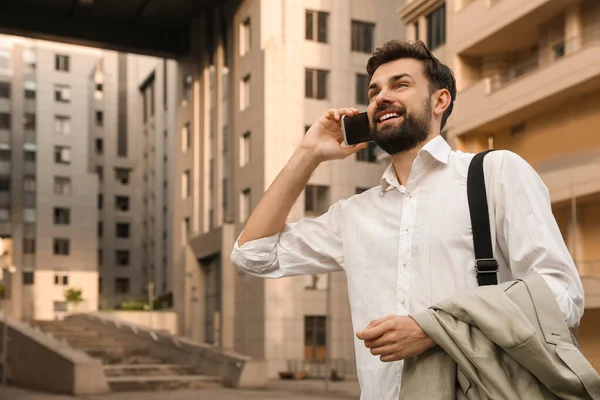 Bonito homem falando ao telefone na cidade moderna — Fotografia de Stock