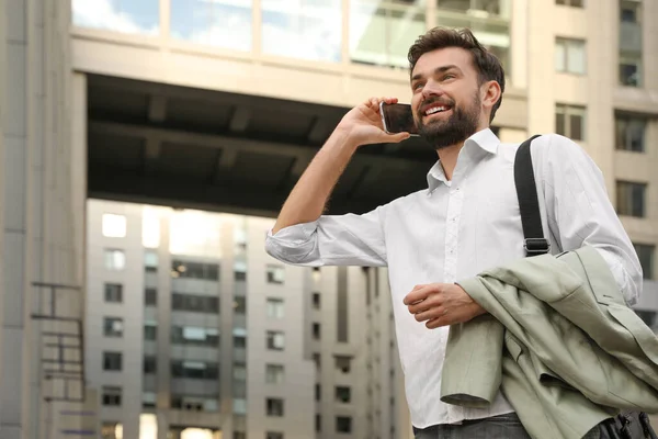 Bonito homem falando ao telefone na cidade moderna — Fotografia de Stock