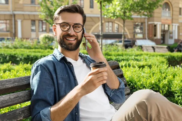 Bonito homem falando ao telefone no parque — Fotografia de Stock