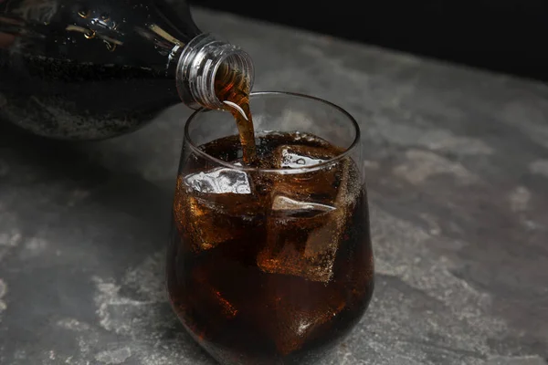 Tuang minuman soda menyegarkan ke gelas di atas meja abu-abu — Stok Foto