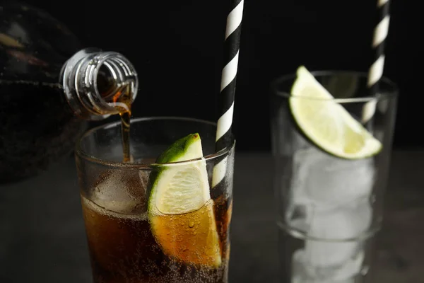 Verfrissende frisdrank in glas gieten op zwarte achtergrond, close-up. Ruimte voor tekst — Stockfoto