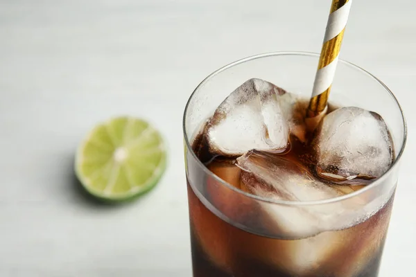 Bebida refrescante com cubos de gelo e palha sobre fundo branco, close-up. Espaço para texto — Fotografia de Stock