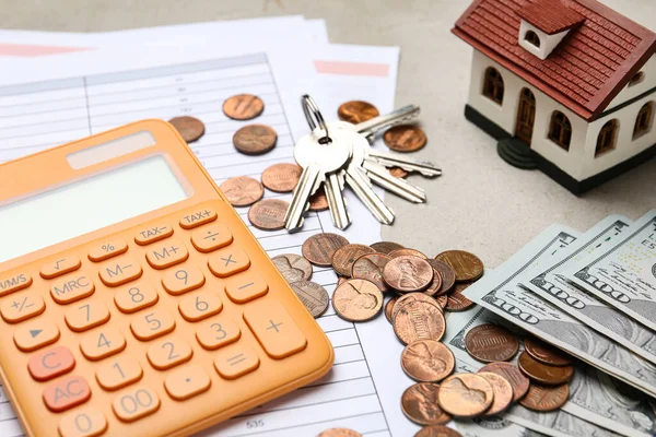 Modelo de casa com calculadora, documentos, chaves e dinheiro na mesa, close-up. Serviço de agente imobiliário — Fotografia de Stock