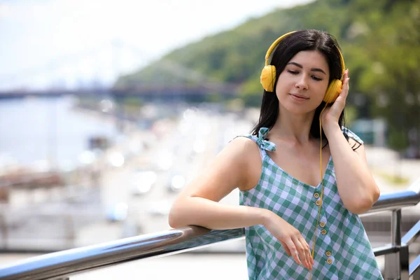 Νεαρή γυναίκα με ακουστικά να ακούτε μουσική σε εξωτερικούς χώρους. Χώρο για το κείμενο — Φωτογραφία Αρχείου