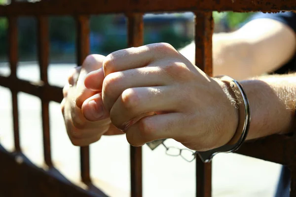 Un hombre esposado en la cárcel al aire libre, de cerca. Derecho penal — Foto de Stock