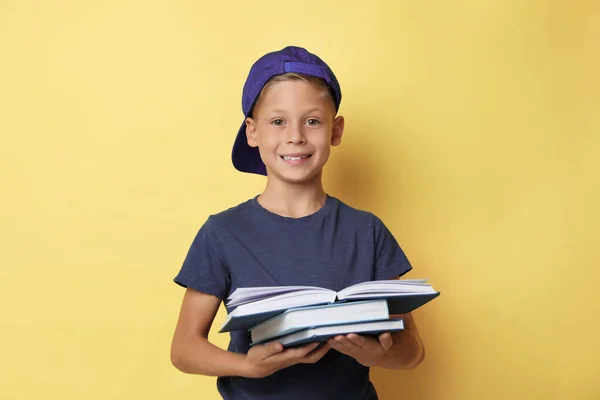 Retrato de menino bonito leitura livro no fundo amarelo — Fotografia de Stock