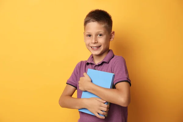 Porträtt av söt liten pojke med böcker på gul bakgrund. Läsbegrepp — Stockfoto