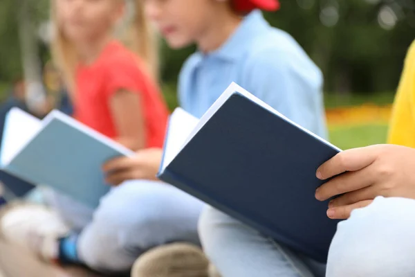 Små barn läser böcker utomhus, närbild — Stockfoto