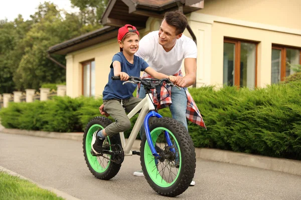 Papa enseigne à son fils à faire du vélo à l'extérieur — Photo