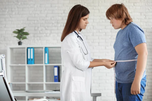 Médico feminino medindo menino com sobrepeso na clínica — Fotografia de Stock