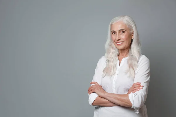 Retrato de una hermosa mujer madura sobre fondo gris, espacio para texto — Foto de Stock