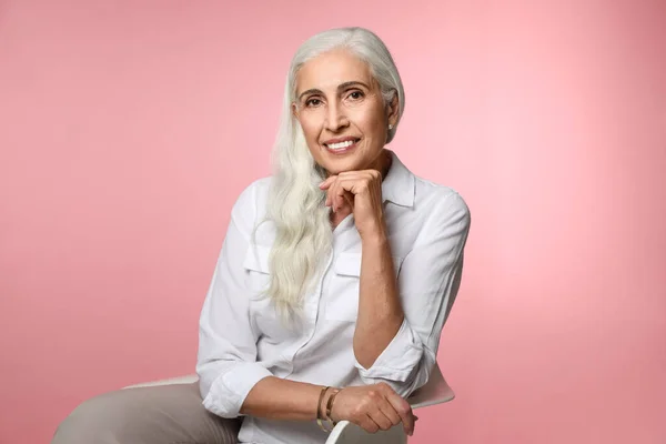 Portret van mooie rijpe vrouw op roze achtergrond — Stockfoto